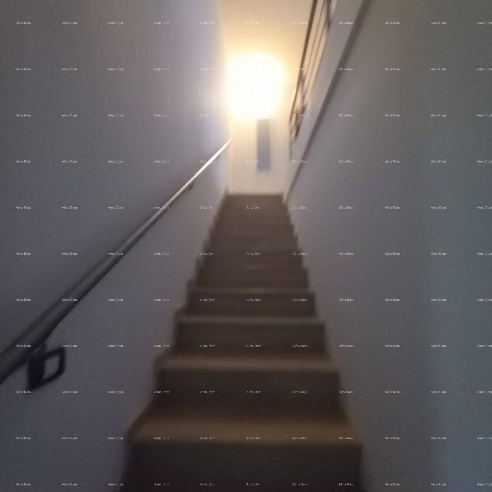 Unscharfes Bild eines Treppenhauses mit Handlauf und heller Beleuchtung.