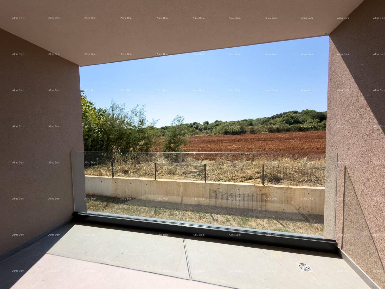 Offener Balkon mit Glasgeländer und weitem Blick über Felder und grüne Landschaft unter blauem Himmel.
