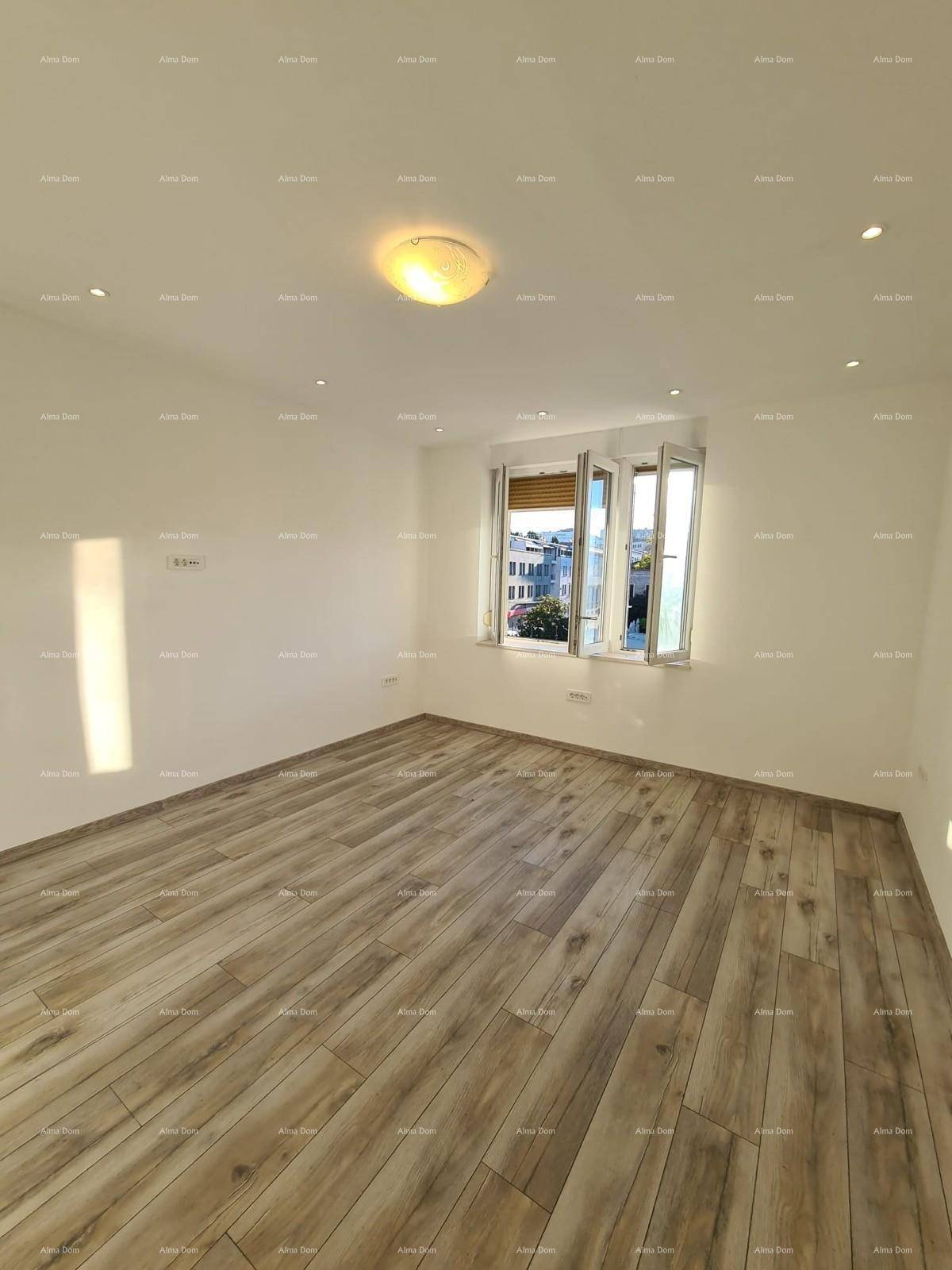Helles, leeres Zimmer mit Holzoptik-Fliesenboden und Einbaustrahlern an der Decke.