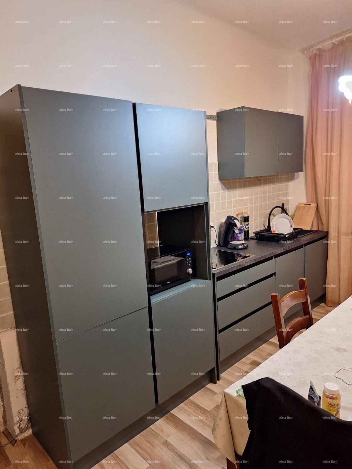 Moderne Küche mit dunklen Schränken, Esstisch und integrierten Geräten.