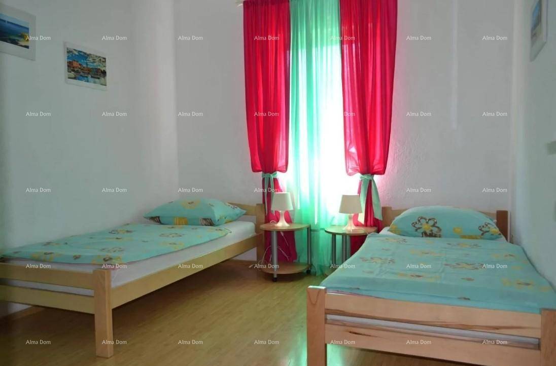 Helles Schlafzimmer mit zwei Einzelbetten und lebhaften roten und grünen Vorhängen.