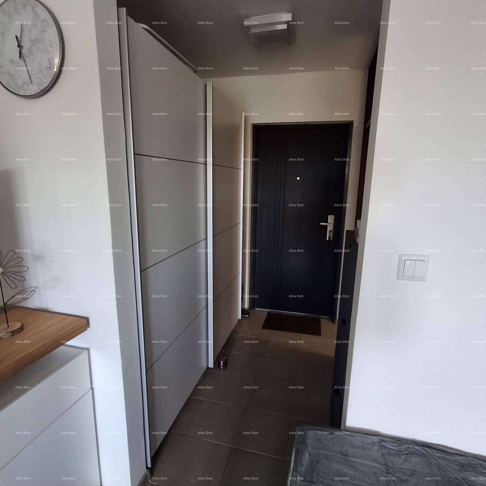 Heller Eingangsbereich mit moderner Garderobe und Sicherheitstür.