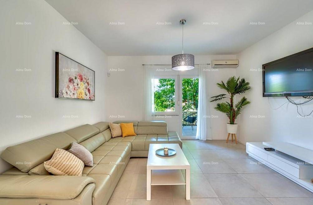 Helles Wohnzimmer mit beigem Ecksofa, Fliesenboden und Zugang zum Balkon.