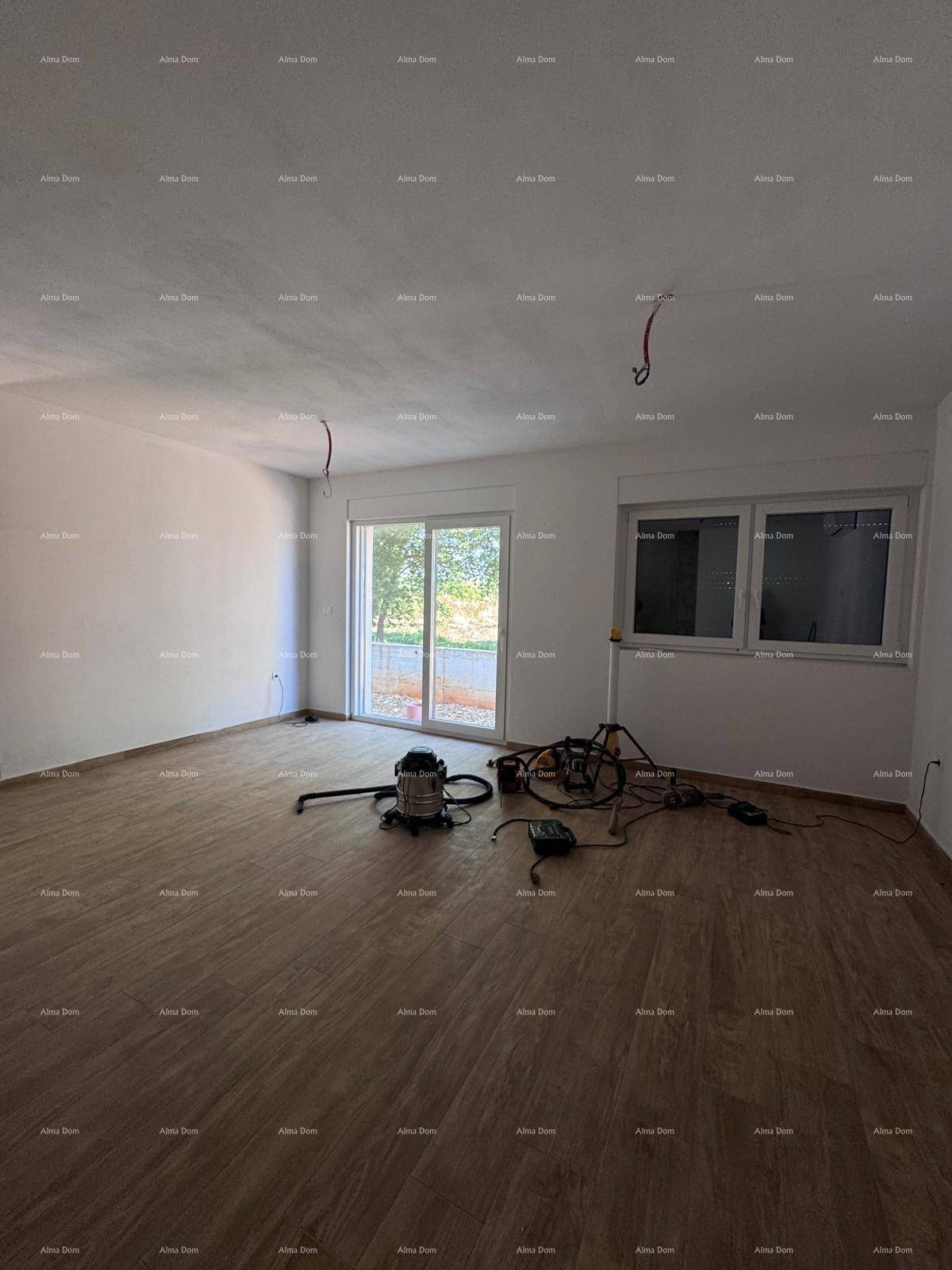 Heller Wohnraum im Rohbau mit Holzboden, großen Fenstern und Schiebetür, bereit für den Innenausbau.