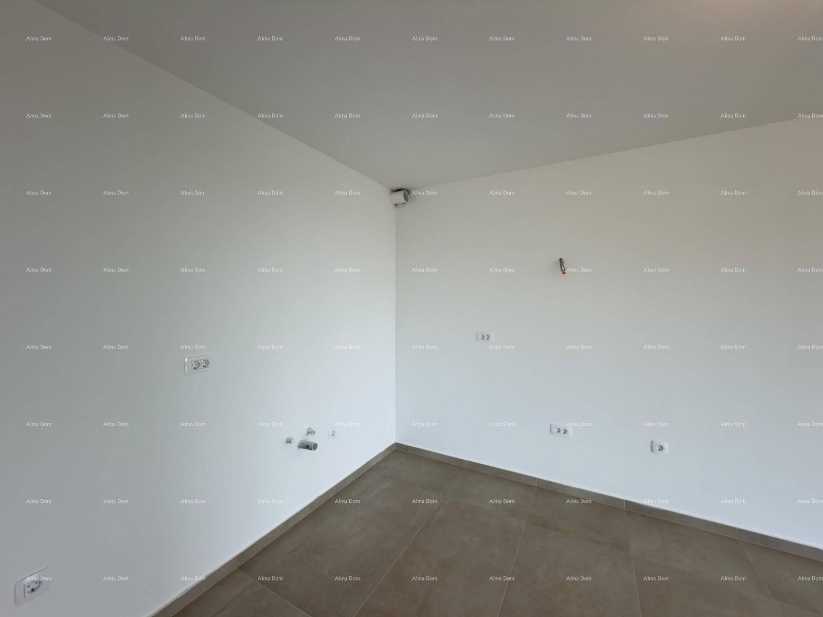 Ecke eines leeren Raumes mit Fliesenboden und Anschlüssen für eine zukünftige Küche.