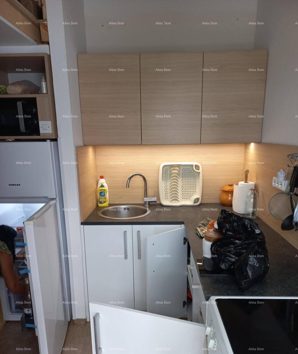 Kompakte Küchenzeile mit Spüle, Oberschränken und integrierten Geräten für effizientes Kochen.