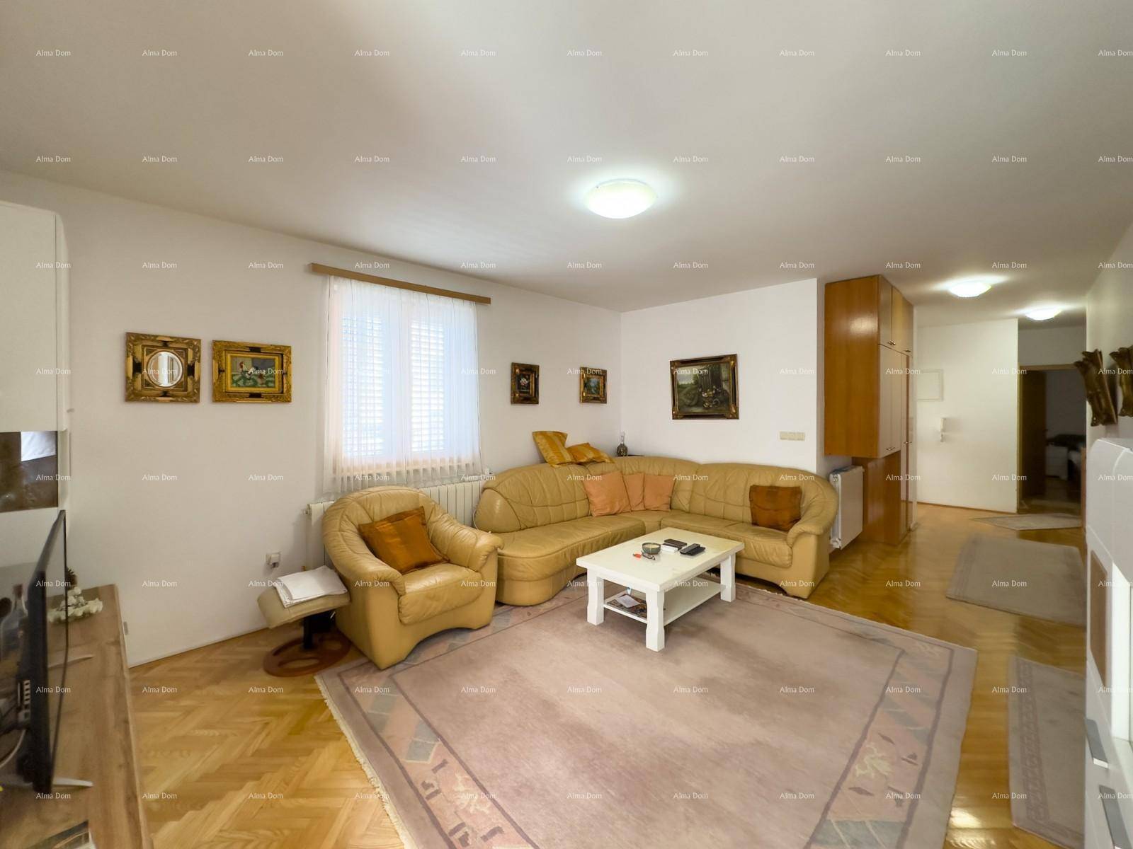 Geräumiges Wohnzimmer mit beiger Sitzgruppe, Teppich und Parkettboden.