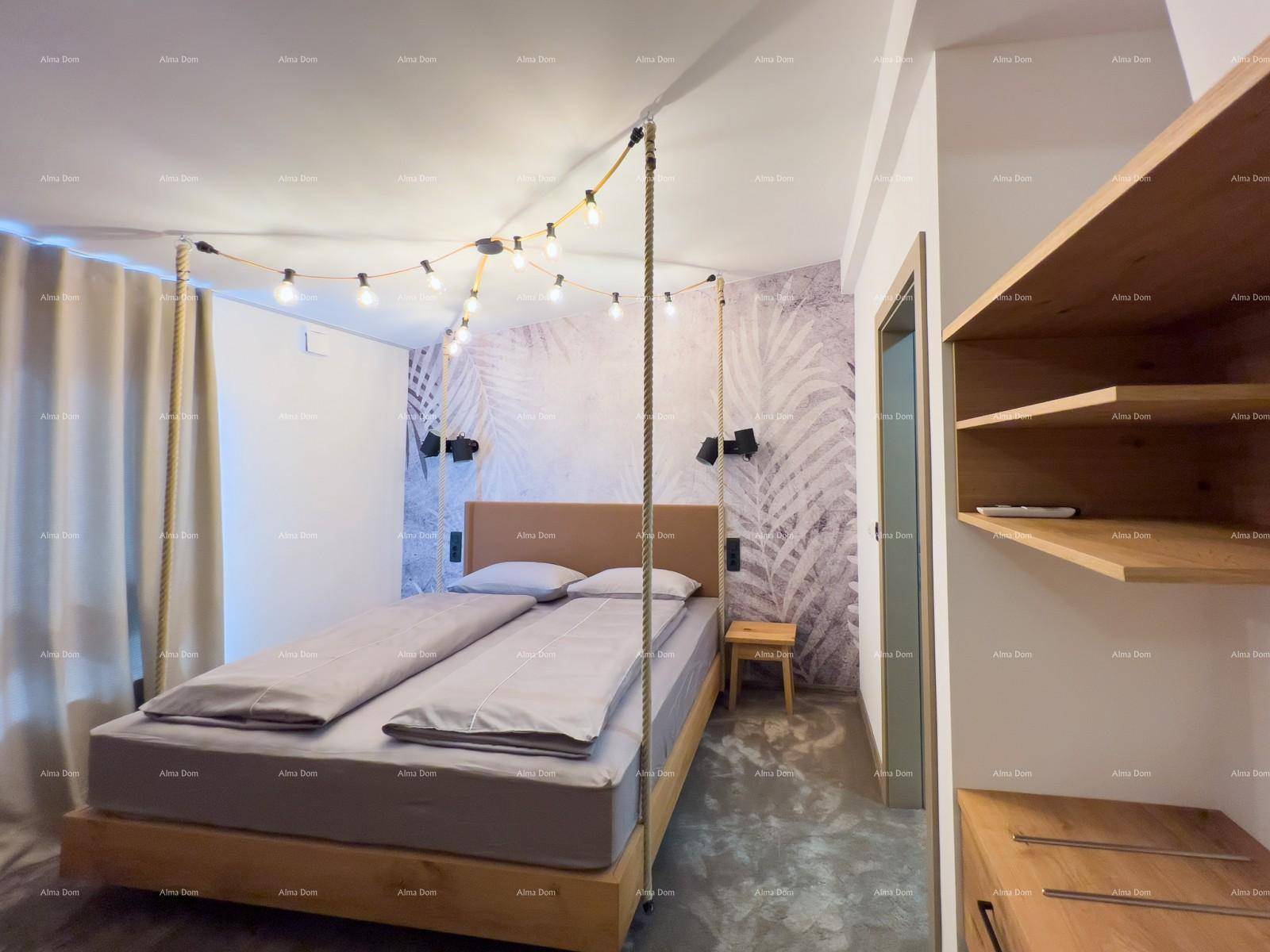 Schlafzimmer mit Doppelbett, Holzkopfteil, dekorativer Lichterkette und einer Wand mit Blattmuster.