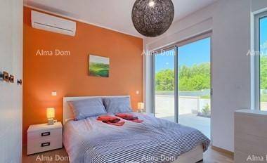 Gemütliches Schlafzimmer mit orangefarbener Akzentwand, Doppelbett und Zugang zur Terrasse.