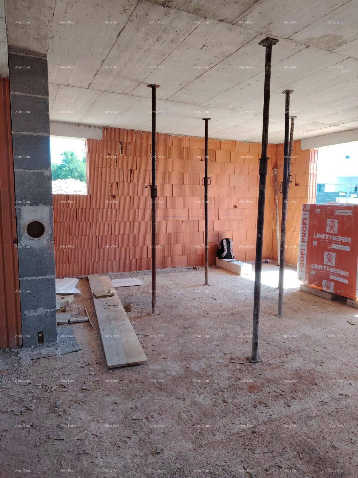 Rohbau-Innenraum mit Ziegelwänden, Deckenstützen und einem Fenster, das Tageslicht hereinlässt.