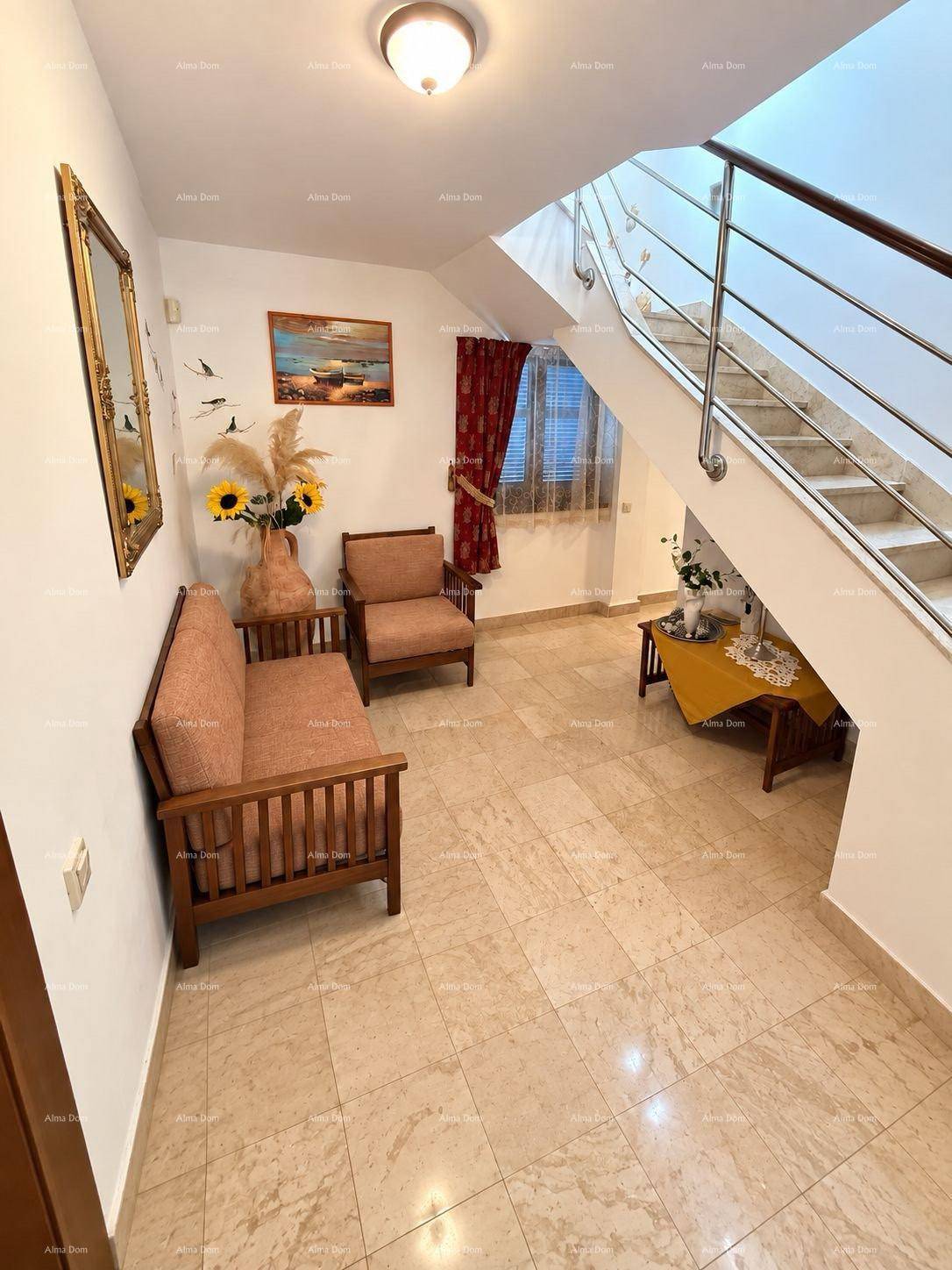 Geräumiger Flur mit heller Fliesenboden, Treppe und Sitzgelegenheiten.
