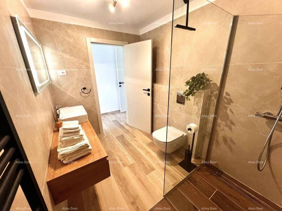 Stilvolles Badezimmer mit Holzwaschtisch, begehbarer Dusche und hellen Fliesen.