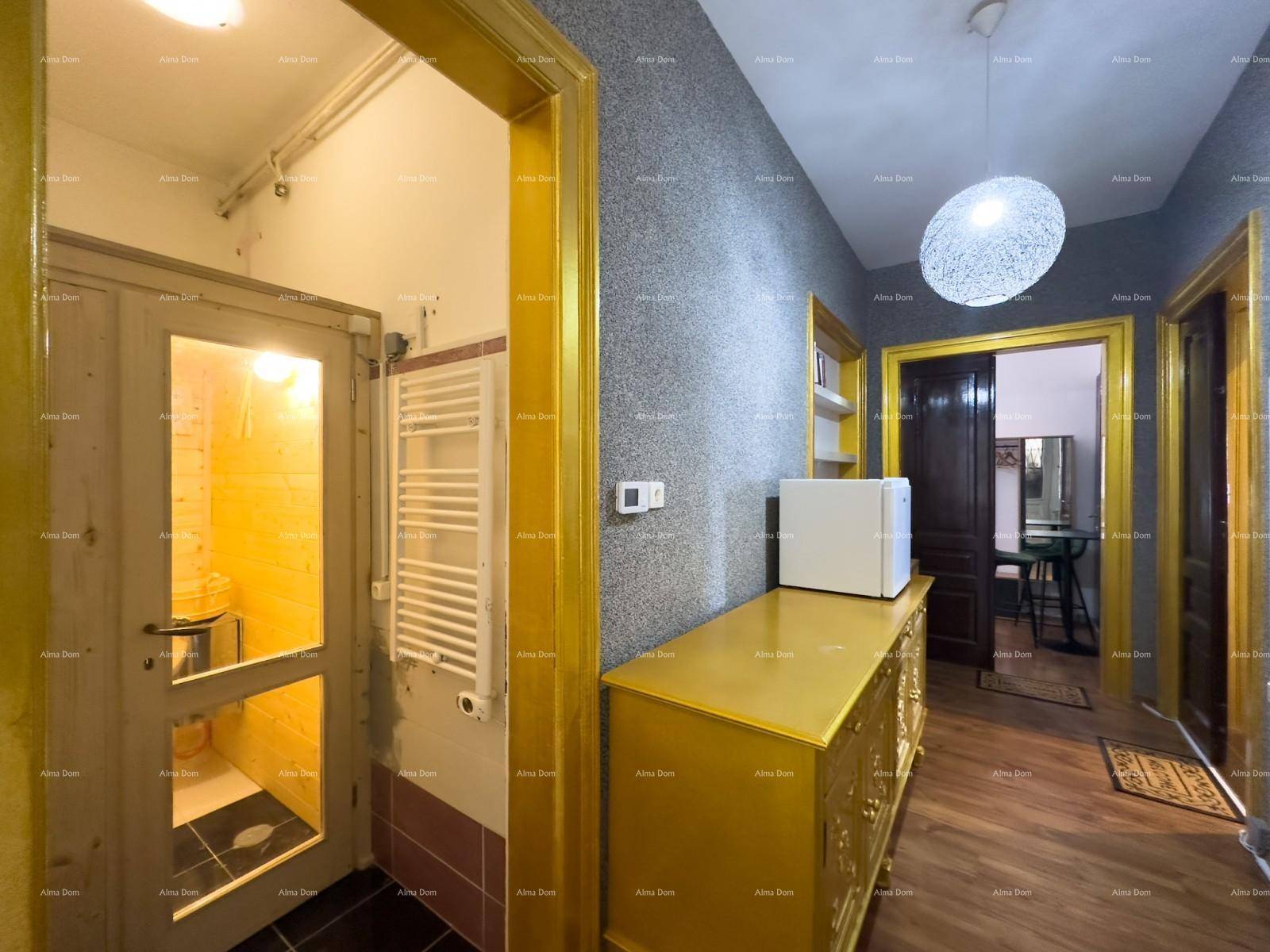 Flur mit grauer Tapete, gelben Türrahmen und einem goldenen Schrank, der zu einer Sauna führt.