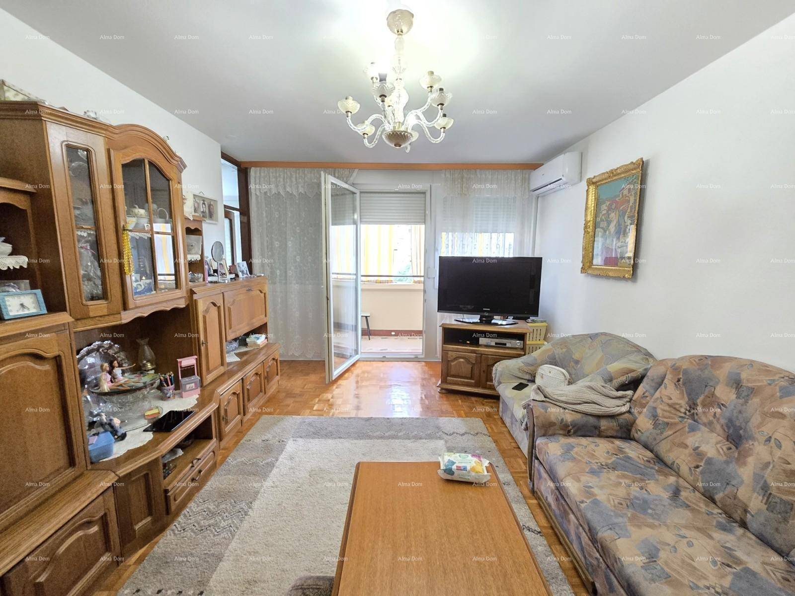 Helles Wohnzimmer mit Holzboden, traditionellen Möbeln und direktem Balkonzugang.