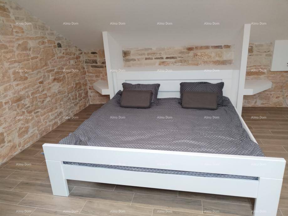 Geräumiges Schlafzimmer im Dachgeschoss mit freiliegenden Steinwänden und modernem Doppelbett, bietet rustikalen Charme.