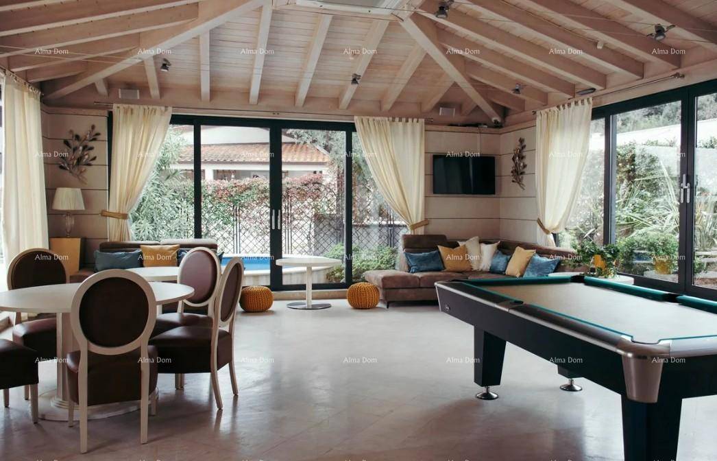 Großzügiger Wohnbereich mit Billardtisch, bequemen Sofas und Zugang zu einem Außenbereich mit Pool.