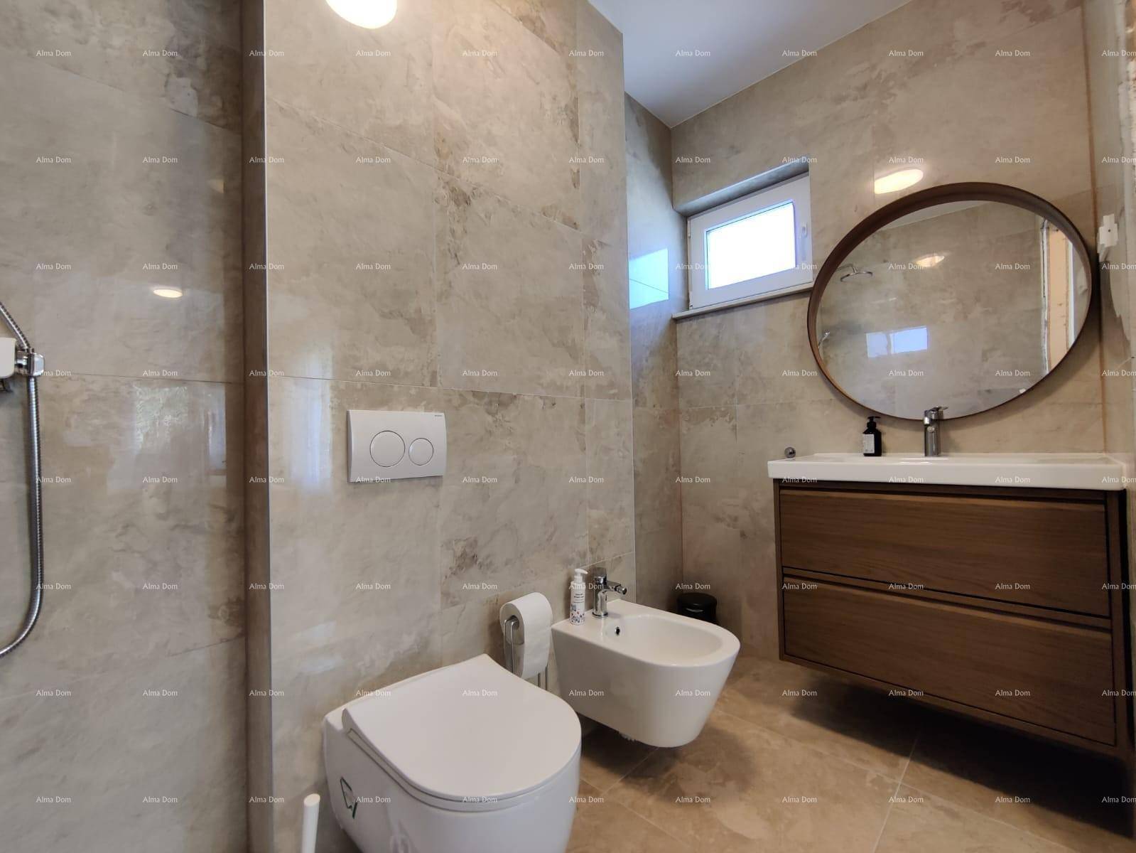 Elegantes Badezimmer mit großformatigen Fliesen, Holzwaschtisch, WC und Bidet.