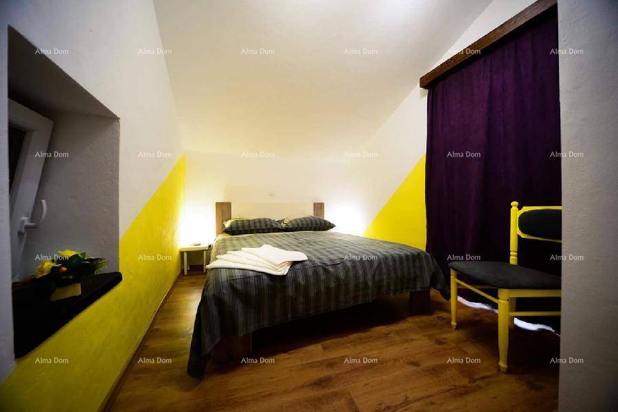 Schlafzimmer im Dachgeschoss mit Doppelbett, Holzboden und farbigen Akzentwänden.