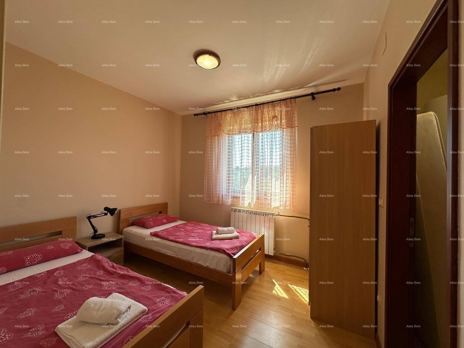 Schlafzimmer mit zwei Einzelbetten, Holzschrank und Fenster, ideal für Gäste oder Kinder.