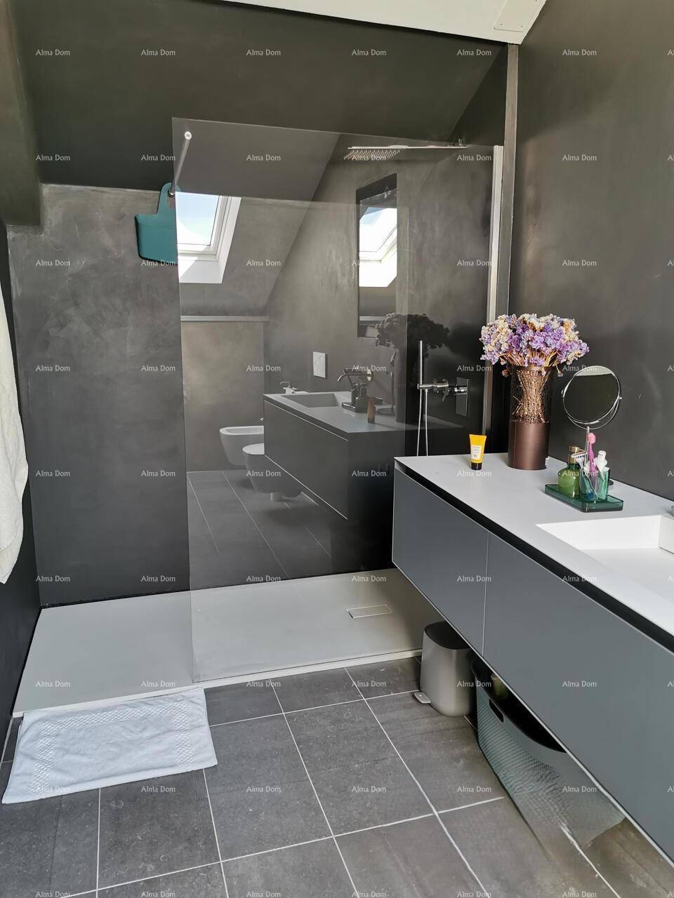 Modernes Badezimmer mit begehbarer Dusche, dunklen Fliesen und Dachfenster.