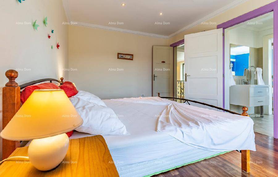 Gemütliches Schlafzimmer mit Holzboden und Blick auf das angrenzende Badezimmer.