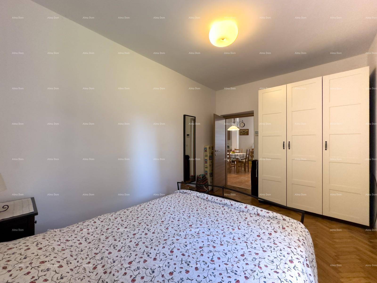 Schlafzimmer mit Doppelbett und weißem Kleiderschrank, mit Blick in den Wohnbereich.