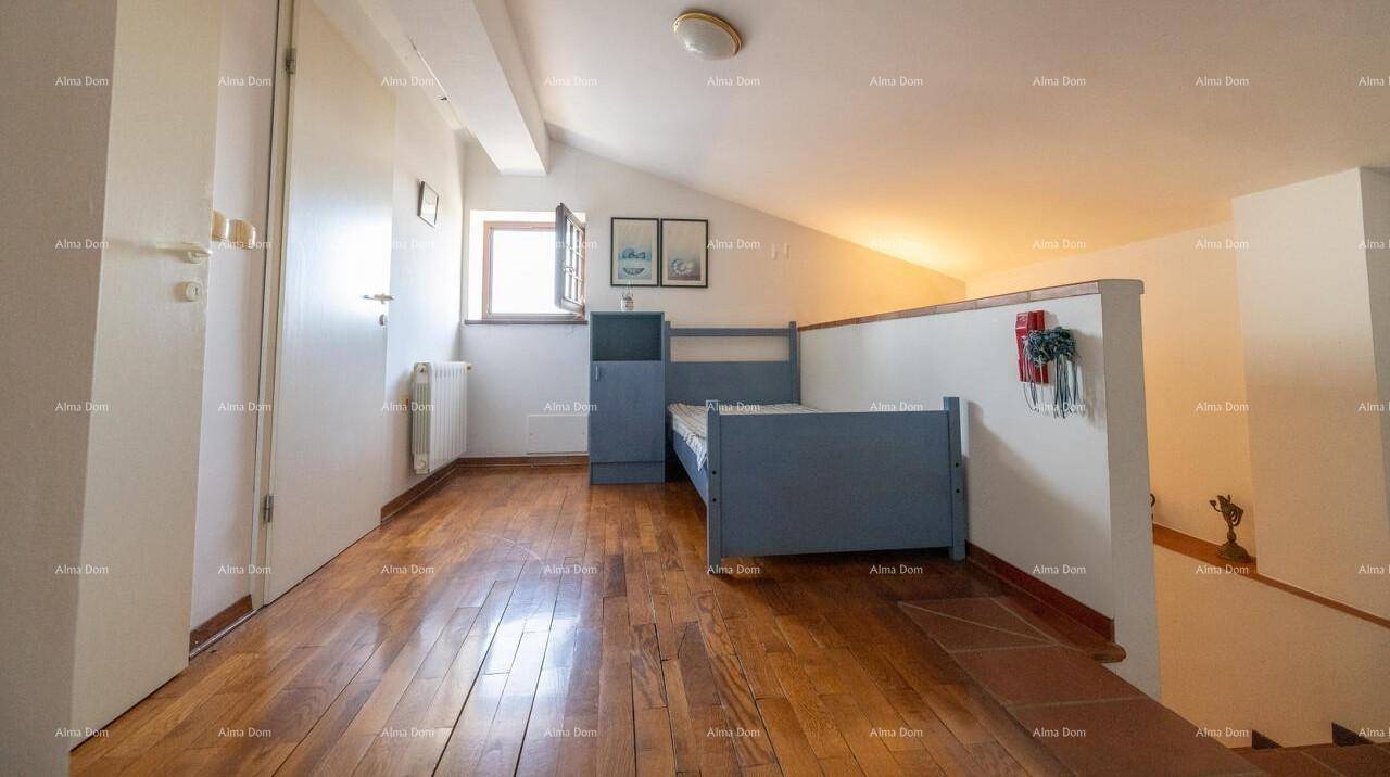 Dachgeschosszimmer mit Holzboden, Bett und Dachschräge, nutzbar als Schlaf- oder Wohnbereich.