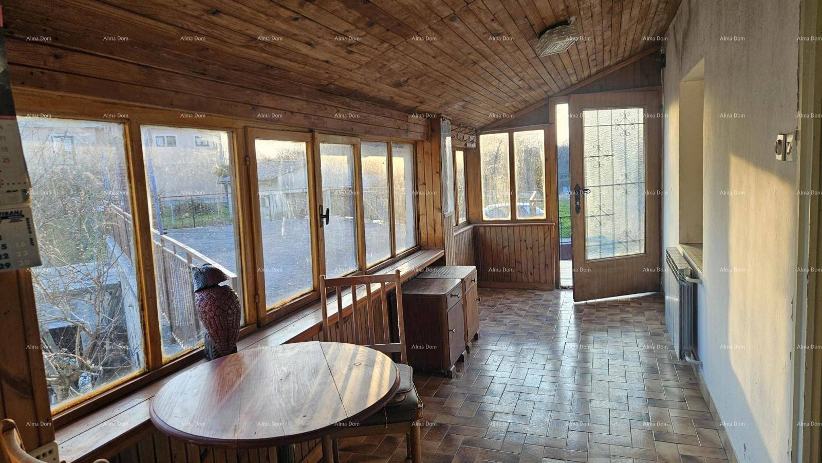 Heller Wintergarten mit vielen Fenstern, Holzboden und Holzdecke, ideal zum Entspannen.