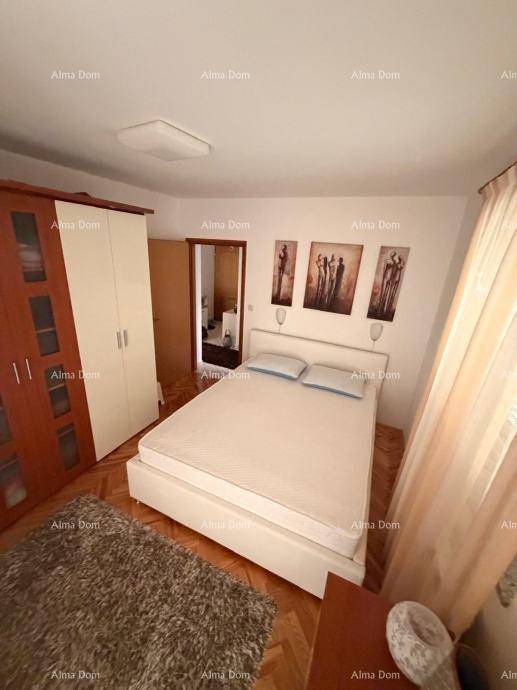 Helles Schlafzimmer mit Doppelbett, großem Kleiderschrank und Fischgrätparkett.