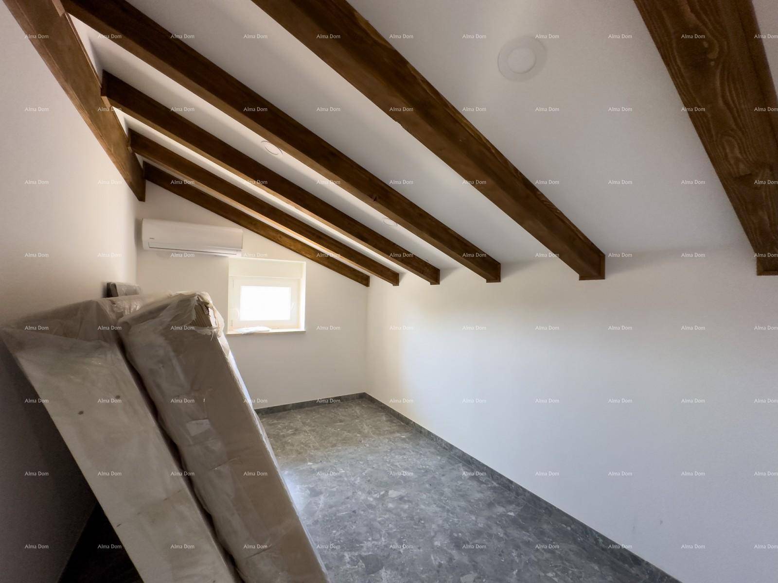 Dachgeschoss-Schlafzimmer mit Holzbalken, schräger Decke, Fenster und Klimaanlage, hell und geräumig.