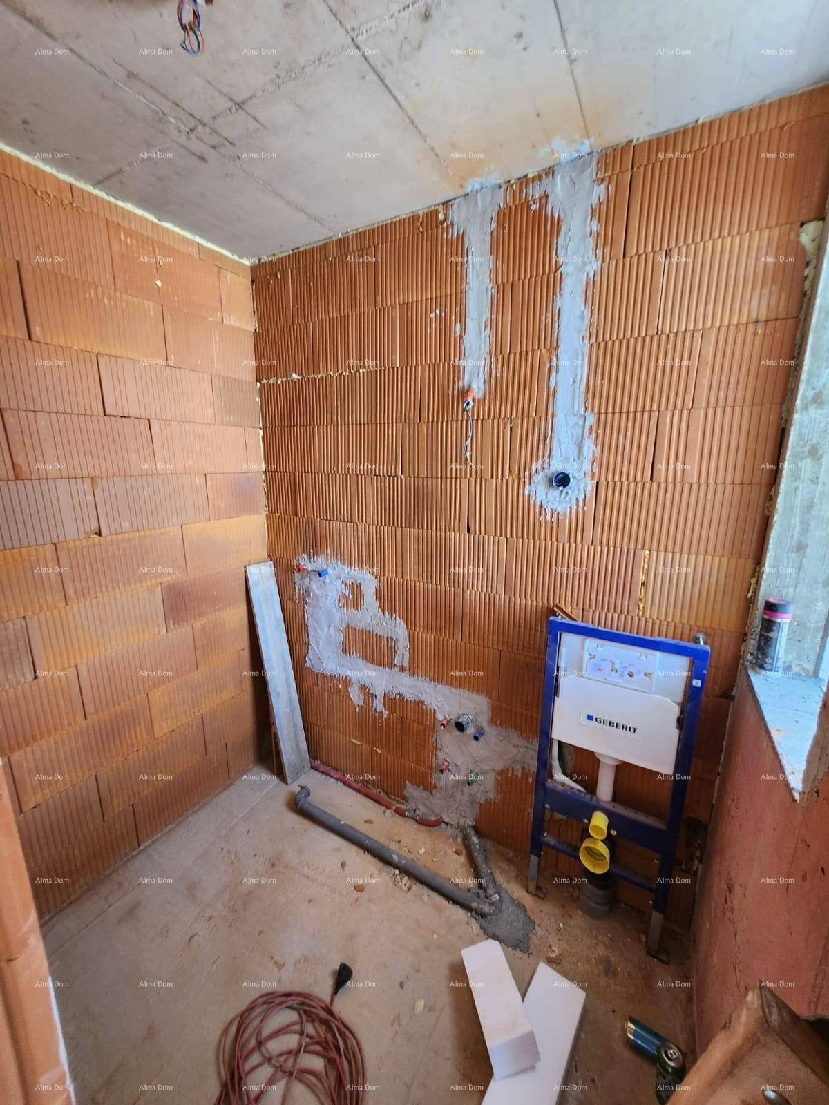 Kleiner Raum im Rohbau mit Ziegelwänden und vorbereiteten Sanitärinstallationen für ein WC.