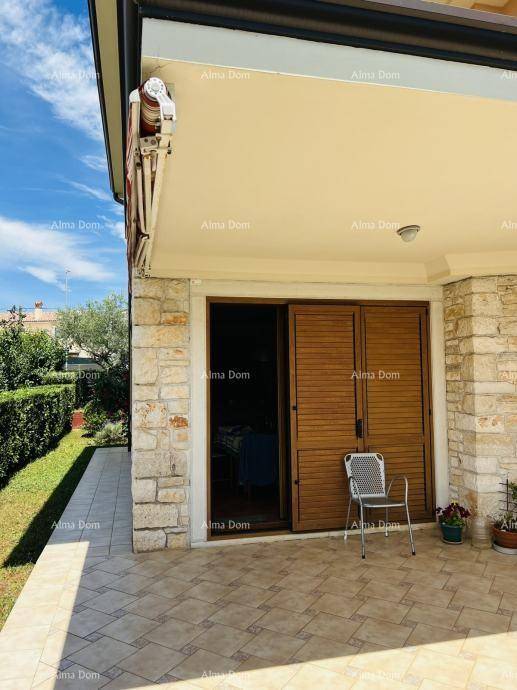 Überdachte Terrasse mit Fliesenboden und Zugang zum Innenbereich, ideal für entspannte Stunden im Freien.