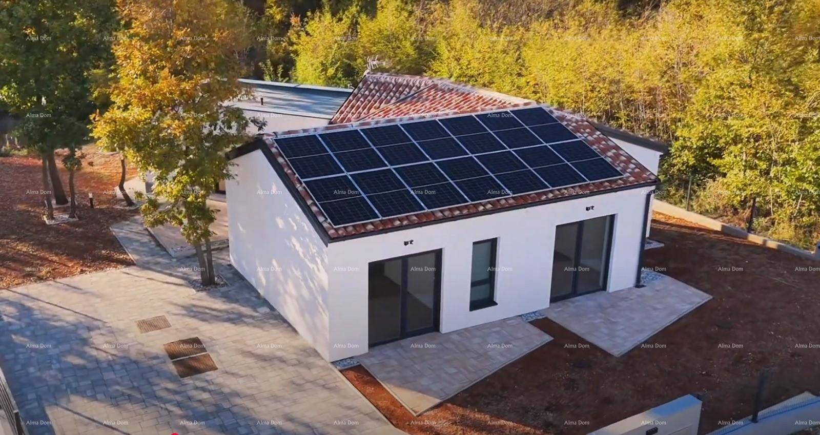 Neubauhaus mit Solaranlage auf dem Ziegeldach und gepflastertem Vorplatz.