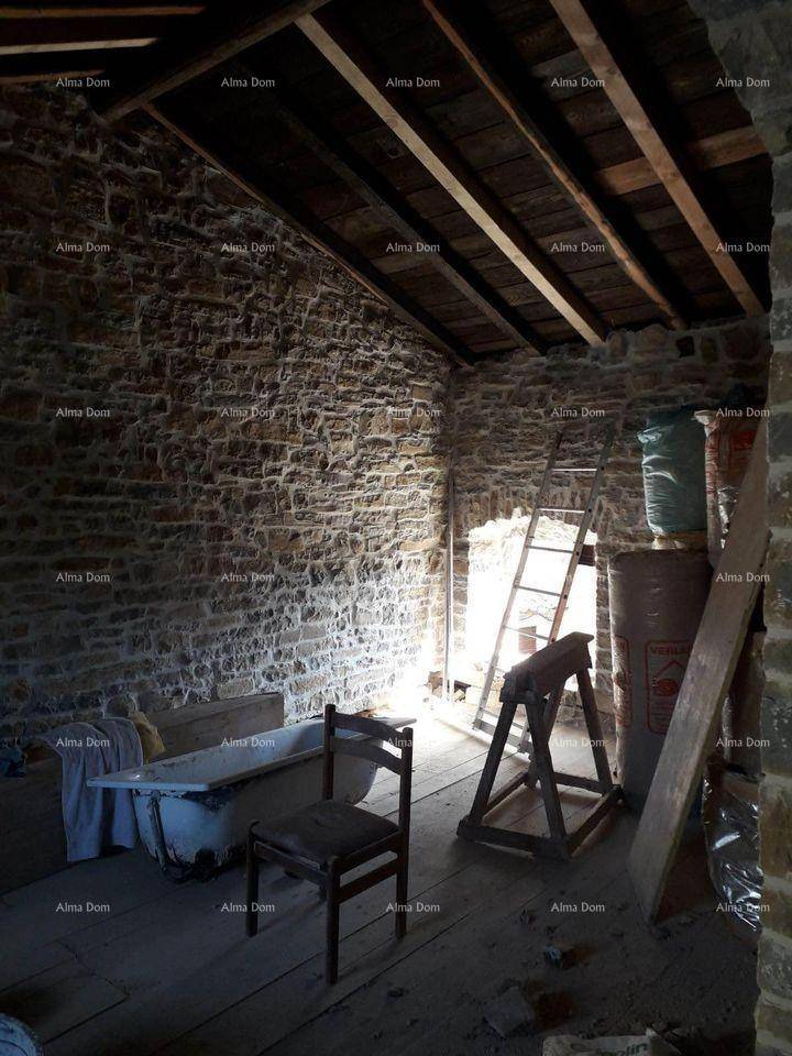 Dachbodenraum mit freiliegenden Steinmauern, Holzboden und einer alten Badewanne.