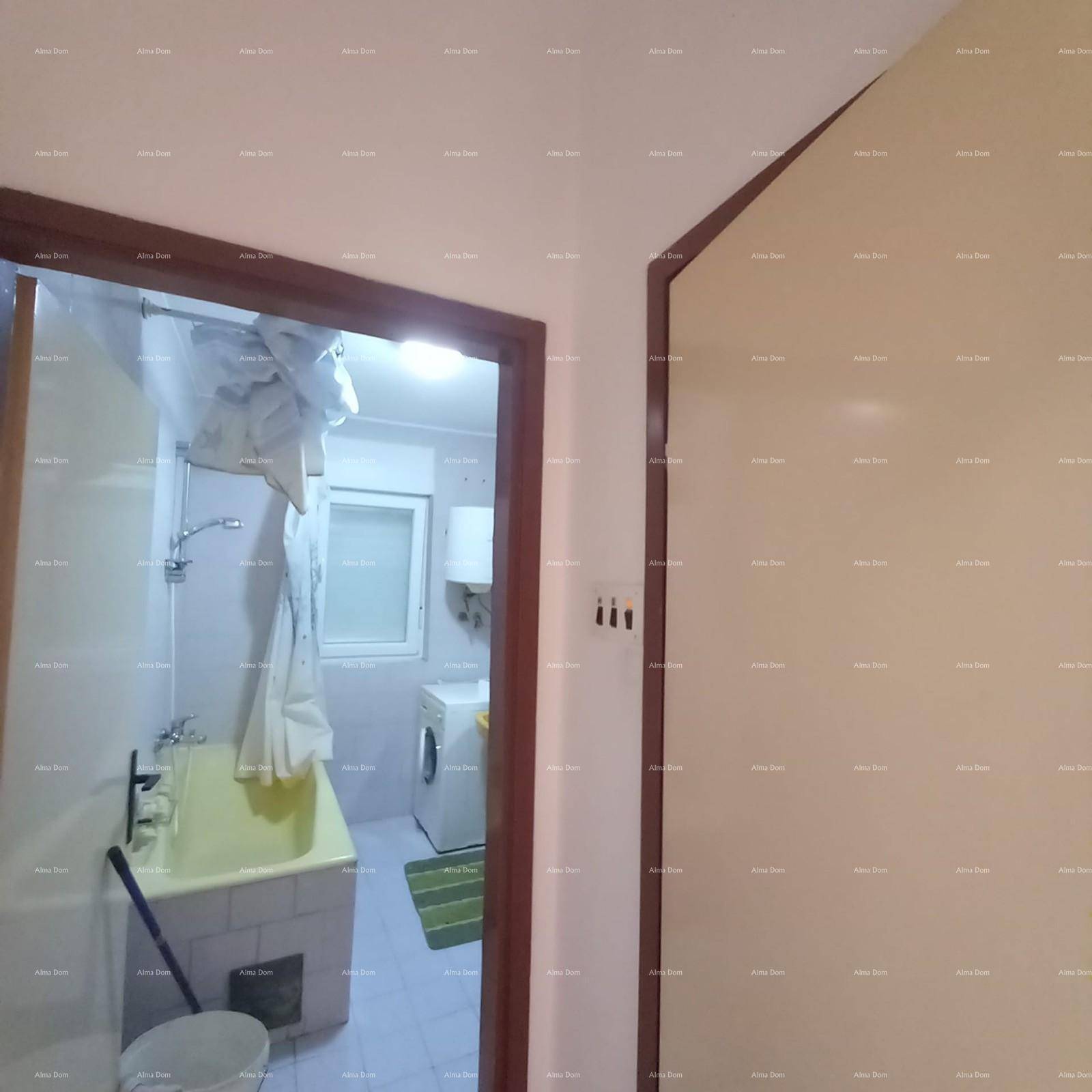 Badezimmer mit gelber Badewanne und Duschvorhang, sichtbar durch eine offene Tür.