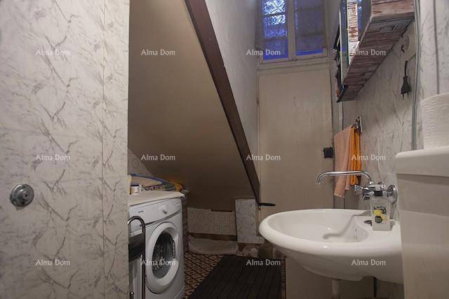 Praktisches Badezimmer mit Waschbecken, Toilette und Waschmaschine unter der Dachschräge.