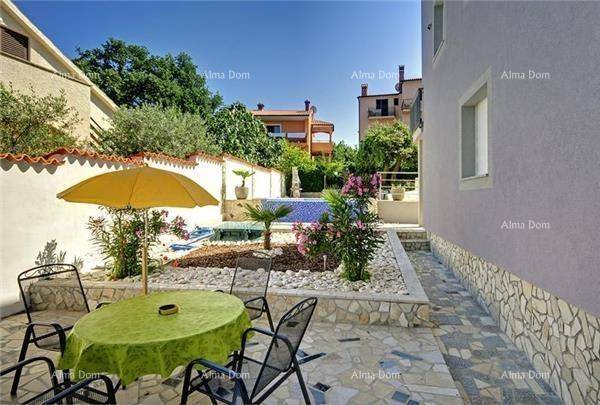 Gemütliche Terrasse mit Sonnenschirm und Sitzgelegenheiten, umgeben von mediterranen Pflanzen.