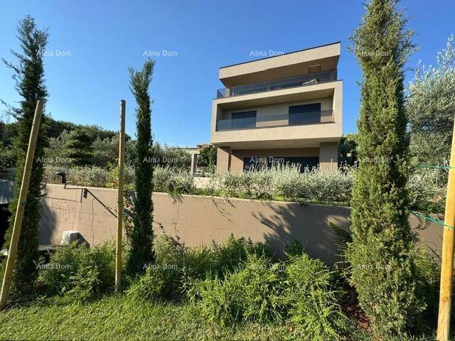 Moderne Villa mit Terrassen und mediterraner Bepflanzung, eingebettet in die natürliche Umgebung.