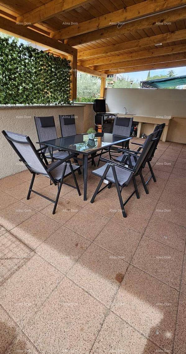 Geräumige überdachte Terrasse mit Esstisch und Stühlen für Mahlzeiten im Freien.