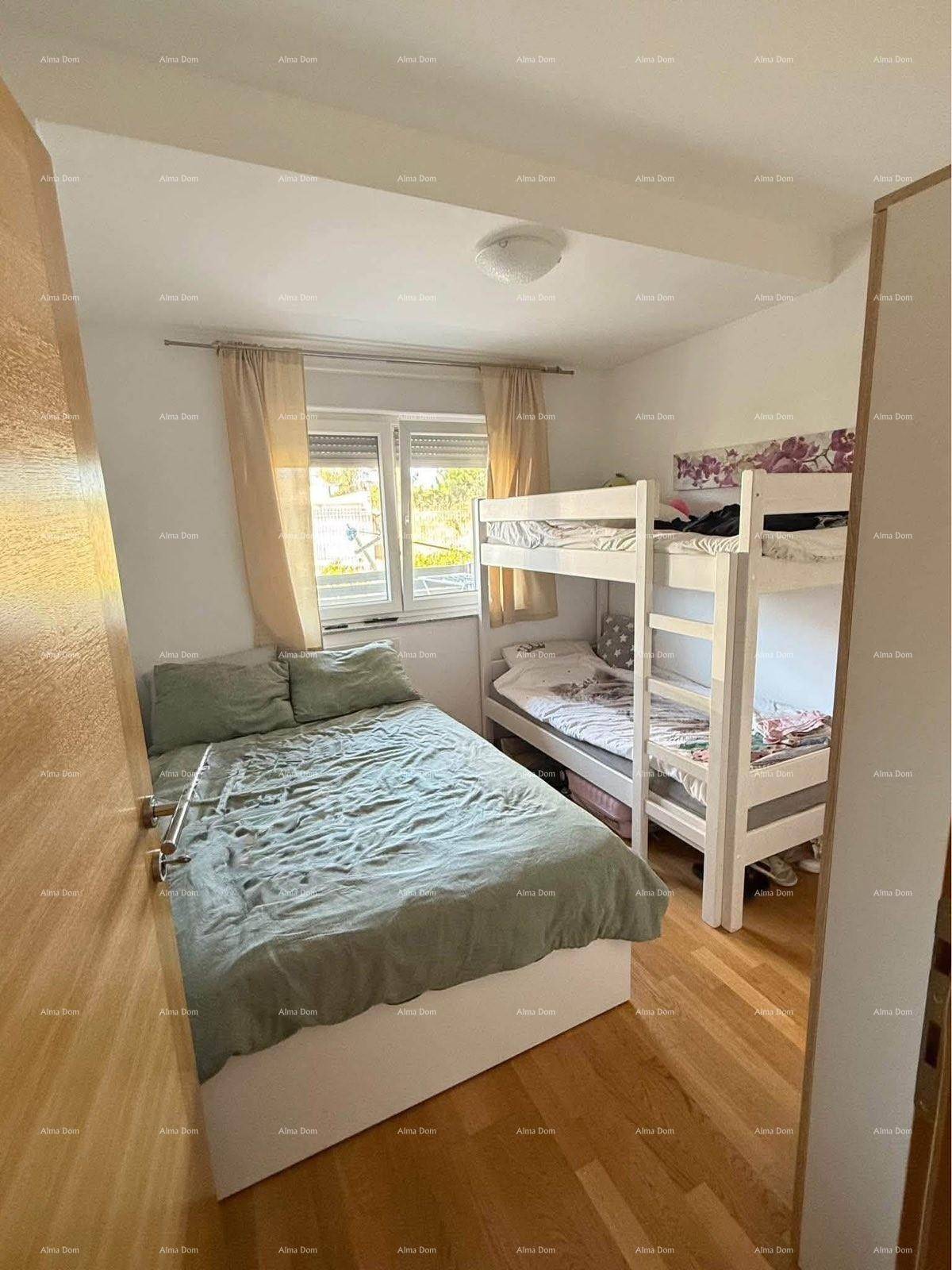 Schlafzimmer mit Doppelbett, Etagenbett und hellem Holzfußboden.