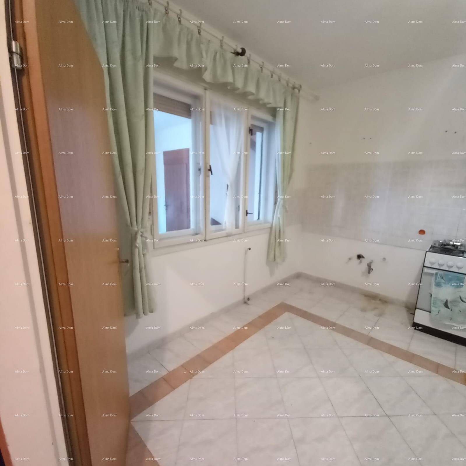 Leere Küche mit Fliesenboden, Fenster und einem Gasherd, bereit für die Einrichtung.