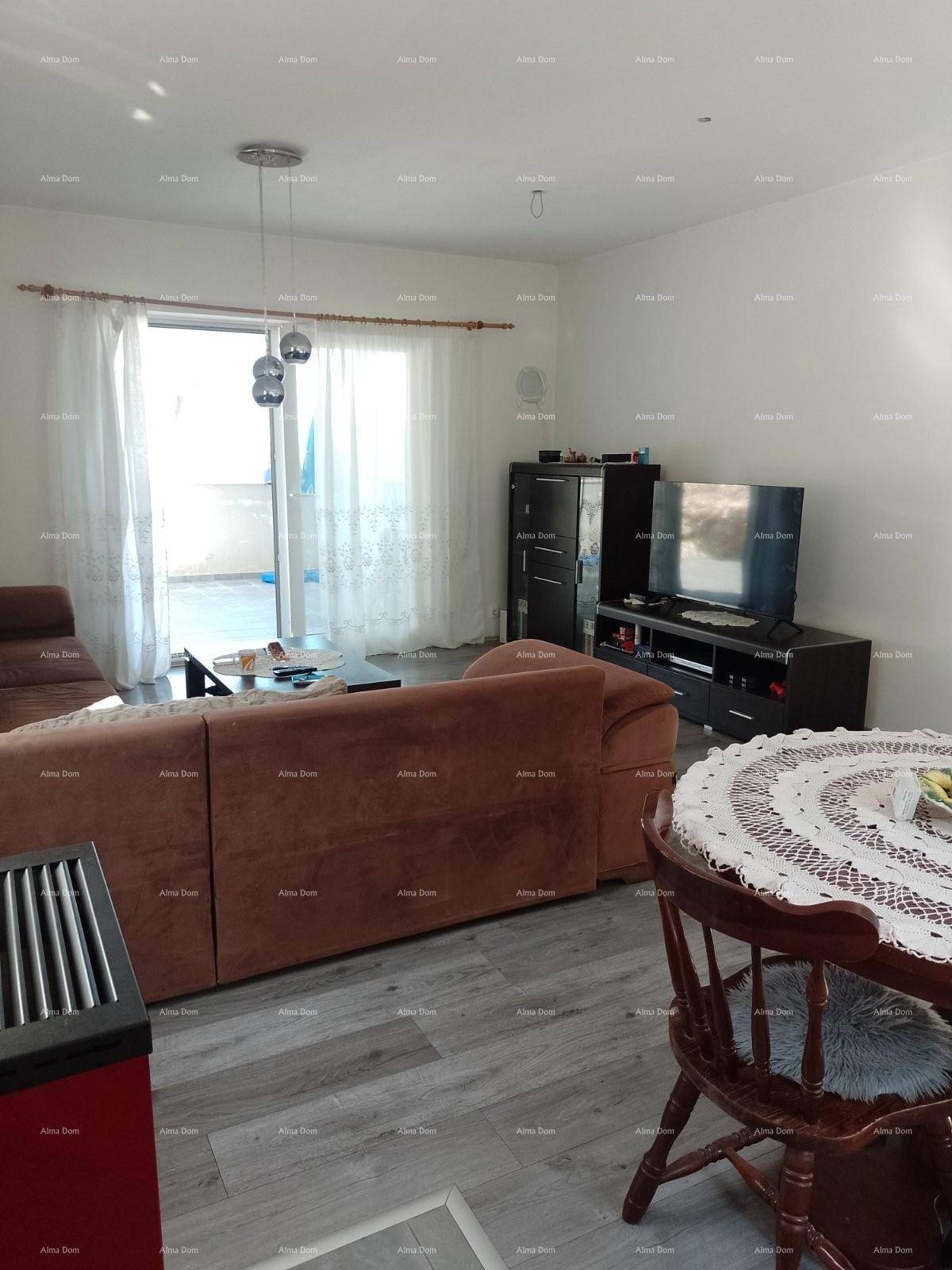 Gemütlicher Wohnbereich mit Sofa, Fernseher und Zugang zu einem Außenbereich.
