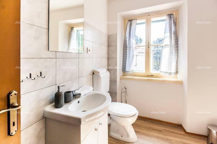 Helles Badezimmer mit Waschbecken, WC, Spiegelschrank und einem Fenster für gute Belüftung.