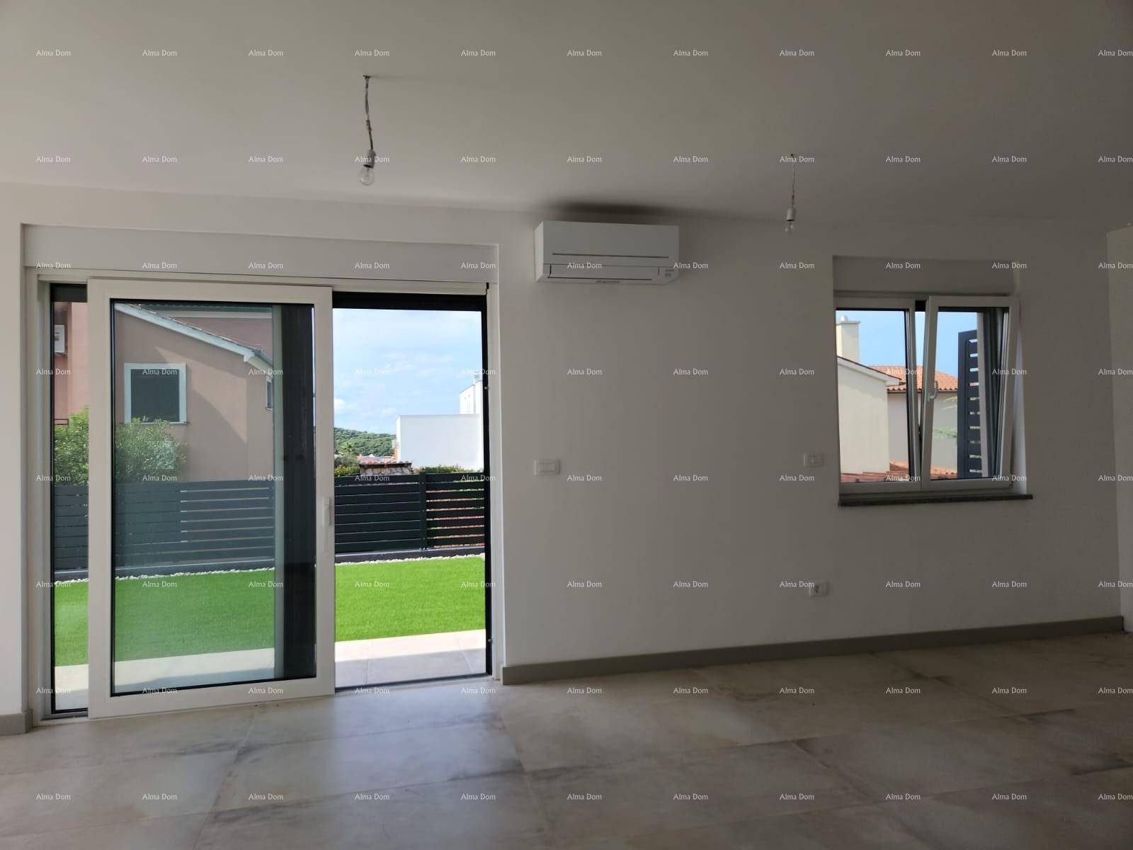 Heller Wohnraum mit Klimaanlage, Fliesenboden und Zugang zum Gartenbereich.