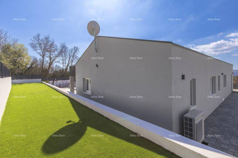 Seitenansicht des modernen Hauses mit gepflegtem Rasen und Klimaanlage im Außenbereich.