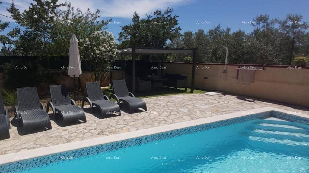 Großer Poolbereich mit Sonnenliegen und schattiger Pergola für entspannte Stunden im Freien.