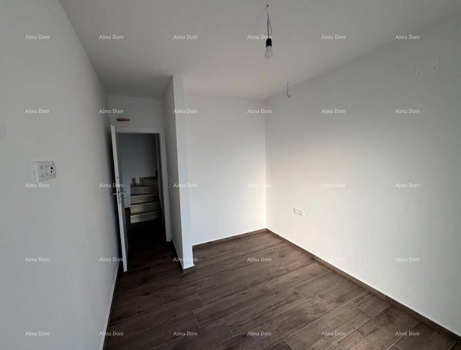 Leeres Zimmer mit dunklem Fliesenboden und Zugang zu einer Treppe, ideal als Schlaf- oder Arbeitszimmer.