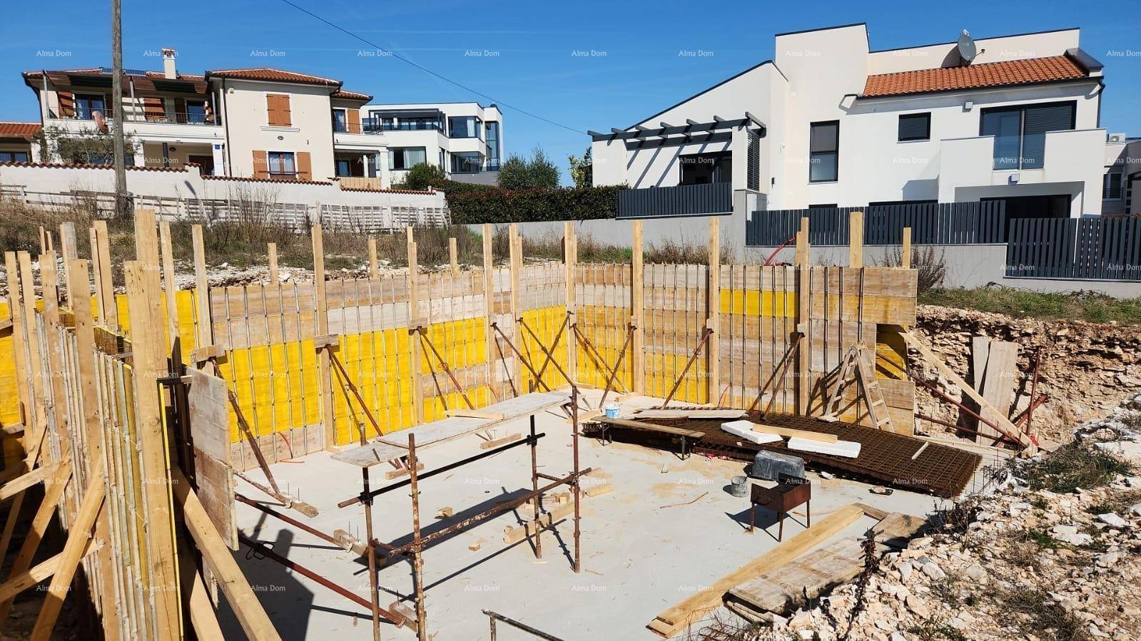 Baustelle mit vorbereitetem Fundament und Schalung für die Wände des Neubaus.