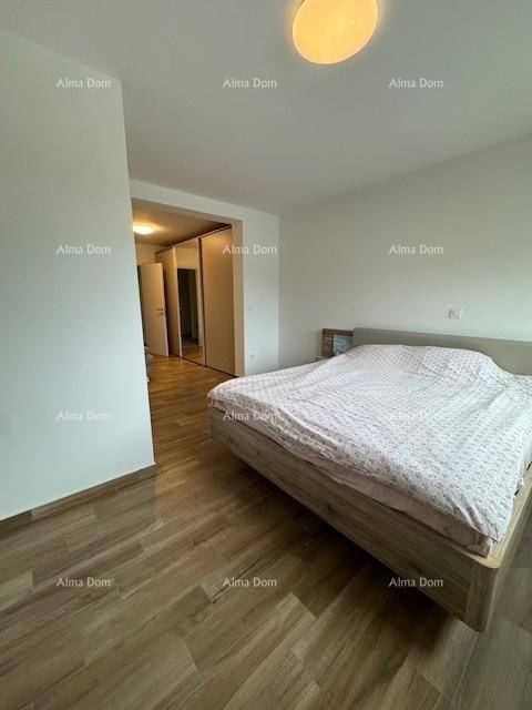 Helles Schlafzimmer mit Holzfußboden und Zugang zu einem Flur mit Spiegelschränken.