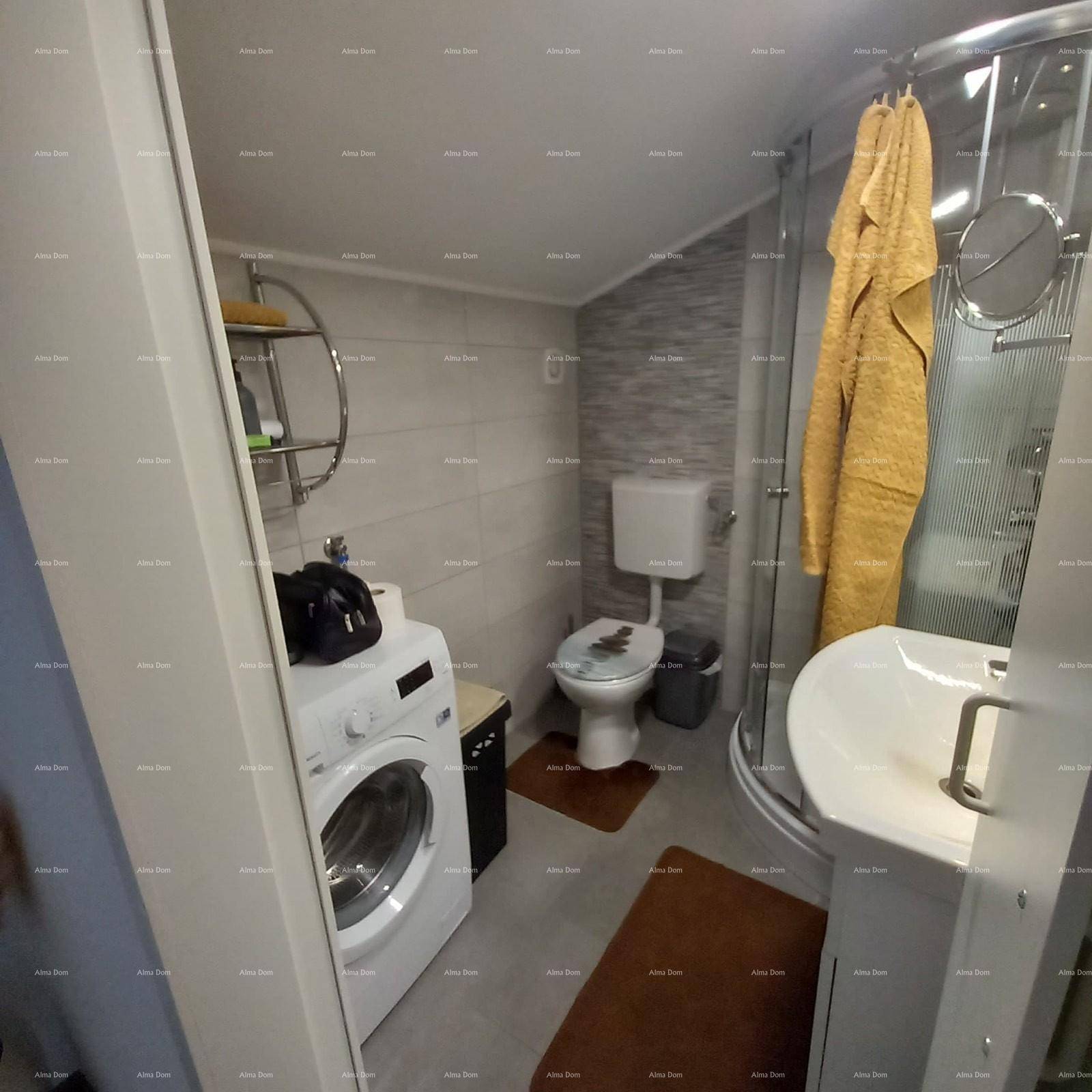 Badezimmer mit Waschmaschine, Duschkabine, WC und Waschbecken.